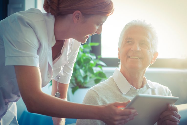 carer and mature man holding ipad